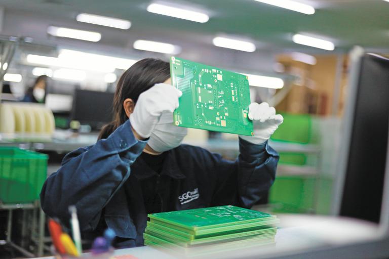 Jiujiang, China - May 26, 2021: Workers produce electronic equipment accessories such as circuit boards in a workshop of a high-tech enterprise in the economic and technological development zone.