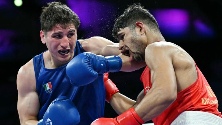 Marco Verde (azul) acomoda un hook en el rostro del hindú Nishant Dev. Foto: AFP.