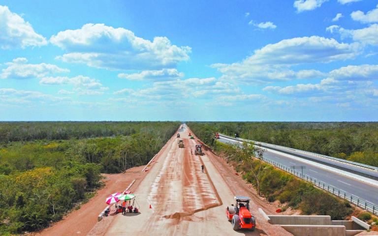 Workers and equipment are seen at the construction site of section 4 of the new Mayan Train route in Valladolid, Yucatan, Mexico, February 26, 2022.  In the eyes of President Andres Manuel Lopez Obrador, the railway his government is building - known as the Tren Maya - will bring modern connectivity to areas for generations deprived of significant economic benefits. But pristine wilderness and ancient cave systems beneath the jungle floor are critically endangered by the railway and its hasty construction, droves of scientists and environmental activists say.  REUTERS/Raquel Cunha     SEARCH