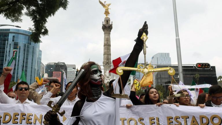 Una joven disfrazada de justicia participa en la marcha contra la reforma al poder judicial. Foto: AFP.