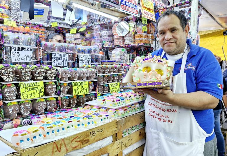 Alfonso Román Díaz mostrando una de las calaveritas de azúcar.