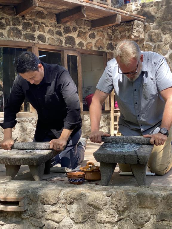 El chef Ángel Vázquez y Drew Deckman en Puebla usando el metate.