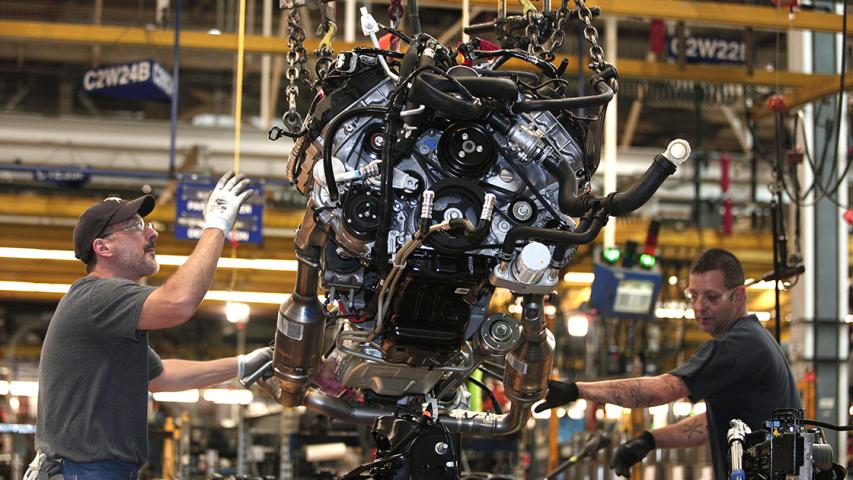 (FILES) In this file photo taken on September 16, 2013, workers install a Ford EcoBoost engine into a 2014 F150 truck chassis on the assembly line at Ford's Dearborn Truck Plant  in Dearborn, Michigan. - Detroit's three automakers have agreed to UAW demands to temporarily shut down all North America plants as a precaution against coronavirus, on March 18, 2020 (Photo by BILL PUGLIANO / GETTY IMAGES NORTH AMERICA / AFP)