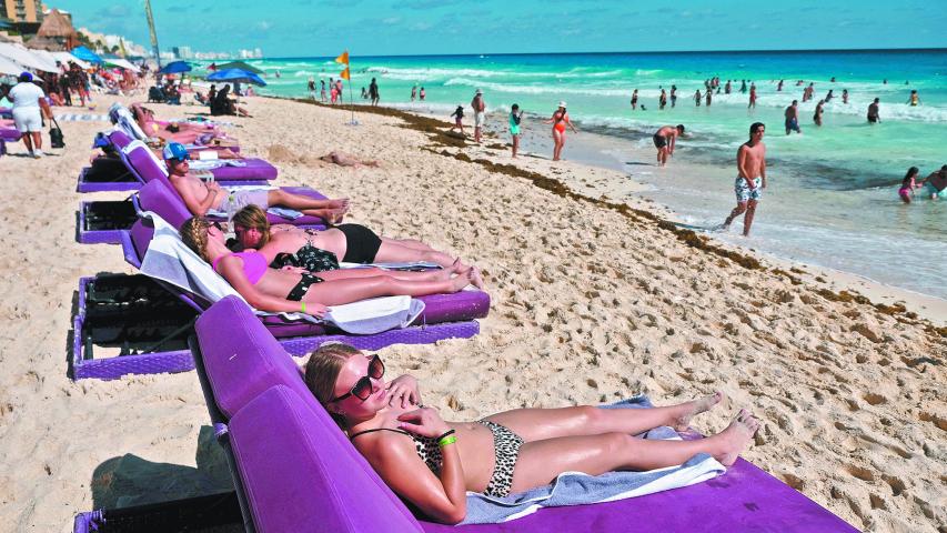 Tourists sun bathe at a beach as the coronavirus disease (COVID-19) pandemic continues, in Cancun, Mexico January 6, 2022. REUTERS/Paola Chiomante NO RESALES. NO ARCHIVES-NARCH/NARCH30