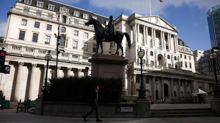 A person walks outside the Bank of England in the City of London financial district in London