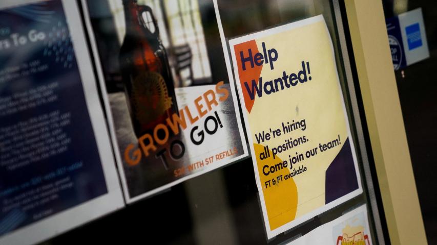 FILE PHOTO: An employee hiring sign is seen in a window of a business in Arlington