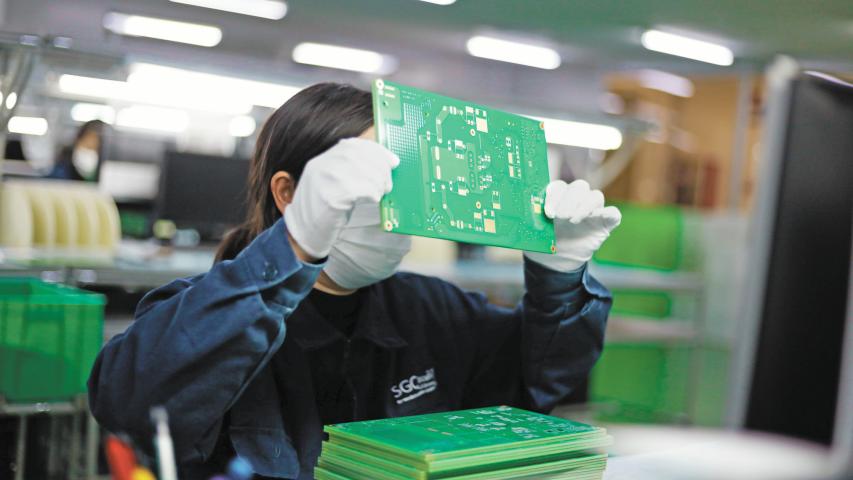 Jiujiang, China - May 26, 2021: Workers produce electronic equipment accessories such as circuit boards in a workshop of a high-tech enterprise in the economic and technological development zone.