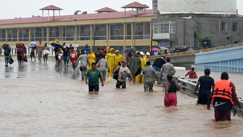 People walk on a flooded street heading to a shelter following Hurricane John in Acapulco, Guerrero State, Mexico, on September 27, 2024. Mexican troops scrambled Friday to help victims of a hurricane that battered the Pacific coast, including the beach resort of Acapulco, which is still recovering from a devastating storm last year. (Photo by Francisco ROBLES / AFP)