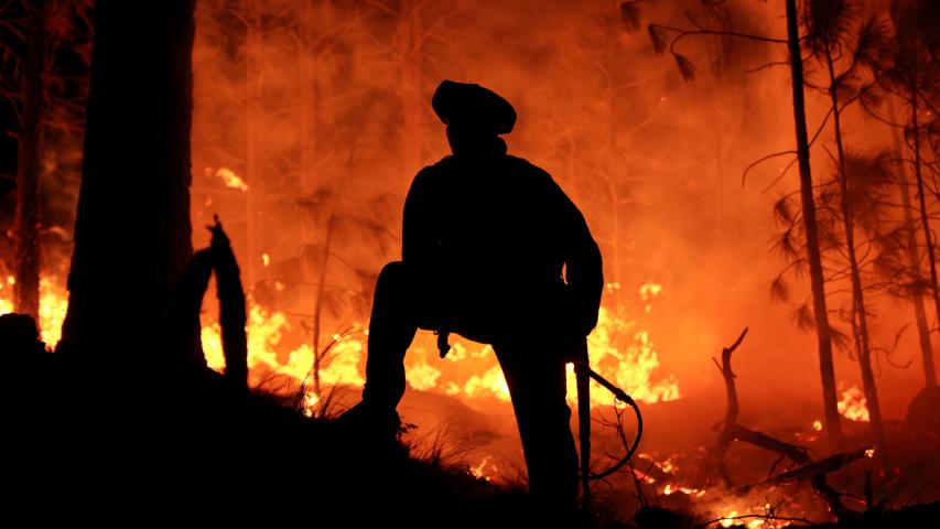 Un hombre trabaja para extinguir un incendio forestal en Intiyaco, en la provincia de Córdoba, Argentina.