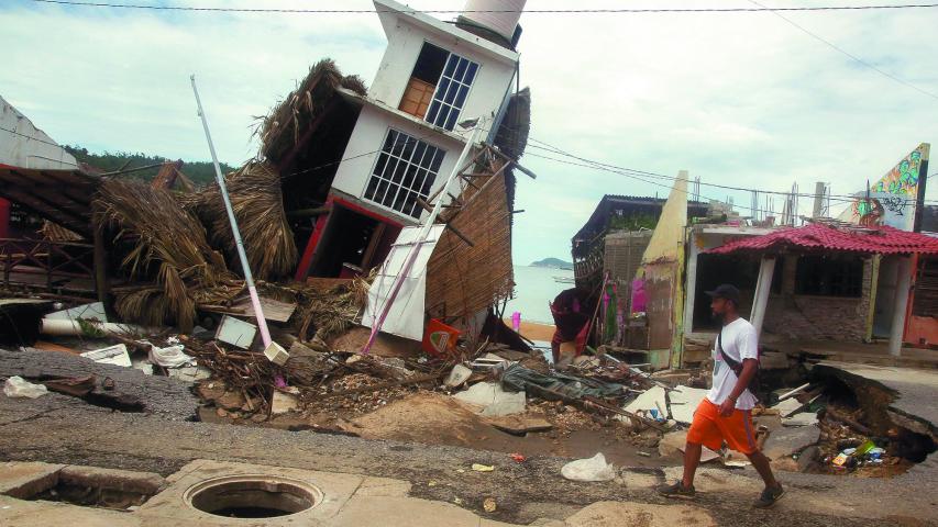 A man walks near a damaged building after the passing of Tropical Storm John, in Puerto Marques, Guerrero state, Mexico September 29, 2024. REUTERS/Javier Verdin