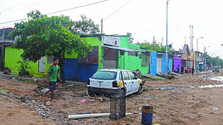 A damaged car remains on a muddy street following Hurricane John in Acapulco, Guerrero state, Mexico, on October 2, 2024. - John made landfall on September 24 as a Category 3 hurricane before churning along the coast for several days and striking land again as a tropical storm. (Photo by Francisco ROBLES / AFP)