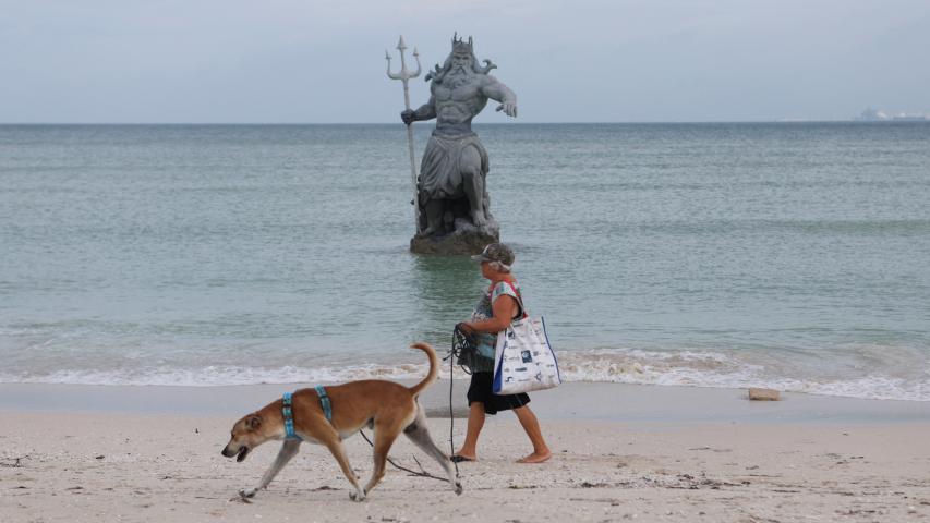 Una mujer pasa junto a una estatua de Poseidón mientras avanza el huracán Milton, en Progreso, 7 de octubre de 2024.