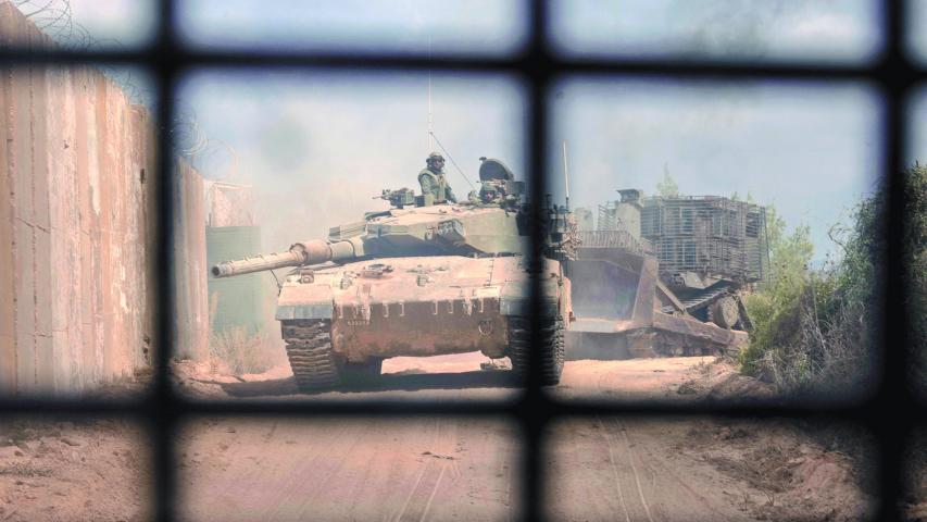 PHOTO TAKEN DURING A CONTROLLED EMBED TOUR WITH THE ISRAELI ARMY AND SUBSEQUENTLY EDITED UNDER MILITARY SUPERVISION -- This picture taken on October 13, 2024 shows an Israeli battle tank entering Lebanon from northern Israel at the southern Lebanese border point of Naqoura. - UN peacekeepers in Lebanon said Israeli tanks broke through a gate to enter a Blue Helmet position in Lebanon on October 13, after blocking their movement the previous day. (Photo by Menahem KAHANA / AFP)