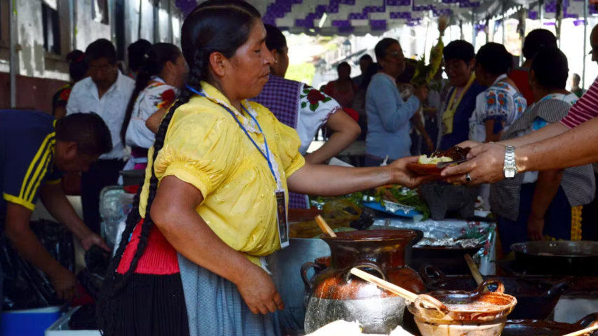 Mujer sirviendo corundas en el Tianguis de Domingo de Ramos en Uruapan, Michoacán, México.