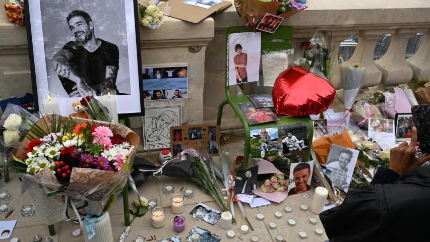 Esta fotografía muestra velas e imágenes del fallecido cantante británico Liam Payne mientras sus fans se reúnen para rendir homenaje al exmiembro de la banda de pop británica One Direction, en el Jardín de las Tullerías de París.