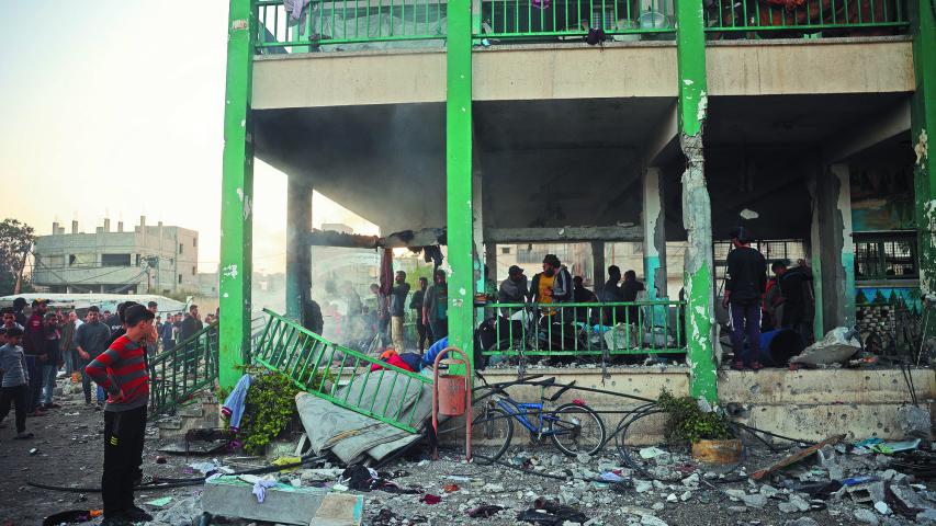 Palestinos observan una escuela destruida por Israel en el campo de refugiados Nusseirat.