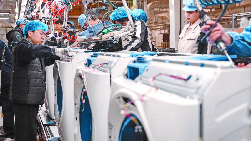 Employees work on a washing machine production line at a factory for Chinese home appliances and consumer electronics company Haier in Qingdao, in eastern China's Shandong province on February 18, 2024. (Photo by AFP) / CHINA OUT - China Out