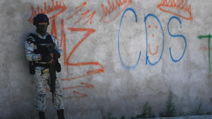 Un soldado mexicano hace guardia junto a unos grafitis del narcotraficante Mayo Zambada y el grupo criminal Cártel de Sinaloa (CDS), en Palmas Altas, municipio de Jerez de García Salinas, en Zacatecas.