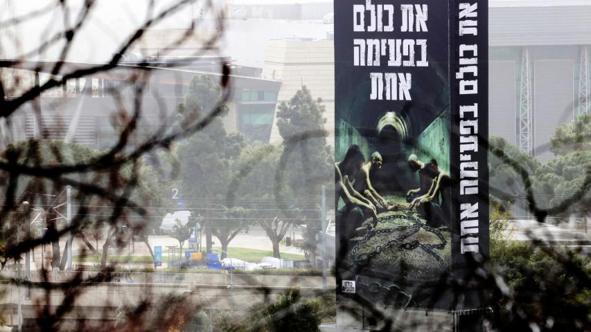 Esta fotografía muestra un cartel que muestra rehenes israelíes y una cadena en el suelo dentro de un túnel con el lema “todos al mismo tiempo” escrito en hebreo, en Tel Aviv, el 5 de marzo de 2025.