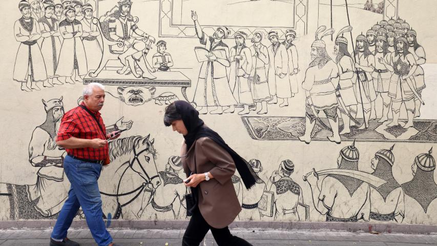 La gente pasa junto a un mural que representa una escena de la epopeya nacional iraní "Shahnameh", en Teherán.
