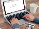 Usuario usando buscador de Google en computadora.