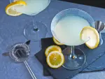 Lemon drop martini cocktail on gray stone and black background