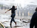 Un manifestante corre mientras se utiliza un cañón de agua contra los manifestantes durante una protesta que exige agua potable limpia.