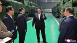 Imágenes divulgadas por KCNA mostraron a Kim de pie junto a los enormes sistemas de misiles en una fábrica con propaganda en las paredes.