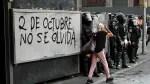 Una anciana pasa junto a agentes antidisturbios que se enfrentan a manifestantes durante una concentración en conmemoración del 57 aniversario de la masacre estudiantil de Tlatelolco de 1968 en la Ciudad de México, el 2 de octubre de 2025.