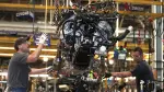 (FILES) In this file photo taken on September 16, 2013, workers install a Ford EcoBoost engine into a 2014 F150 truck chassis on the assembly line at Ford's Dearborn Truck Plant  in Dearborn, Michigan. - Detroit's three automakers have agreed to UAW demands to temporarily shut down all North America plants as a precaution against coronavirus, on March 18, 2020 (Photo by BILL PUGLIANO / GETTY IMAGES NORTH AMERICA / AFP)