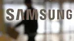 A man walks past the logo of Samsung Electronics displayed on a glass door at the company's Seocho building in Seoul on January 29, 2026. South Korean tech giant Samsung Electronics posted record quarterly profits on January 29, riding strong market demand for its artificial intelligence chips. (Photo by Jung Yeon-je / AFP)
