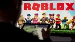 A child poses as he plays a video game on a tablet on the online game platform and game creation system Roblox developed by Roblox Corporation in Terville, northeastern France on March 11, 2026. (Photo by Jean-Christophe VERHAEGEN / AFP)