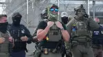 Agentes del Servicio de Inmigración y Control de Aduanas (ICE) montan guardia afuera de Delaney Hall, que se está utilizando como centro del Servicio de Inmigración y Control de Aduanas.