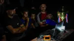 El exfutbolista palestino Fadi Al-Arawi mira un partido del Mundial 2026 en una computadora junto a otras personas en Khan Younis, en la Franja de Gaza.