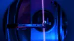 En la imagen se observa un cristal de fluoruro de calcio —alojado en su soporte e integrado con una gran cantidad de núcleos de torio— dentro del sistema de vacío de un reloj nuclear, mientras un haz láser sondea dichos núcleos en un laboratorio de la TU Wien en Viena, Austria. Foto: Reuters