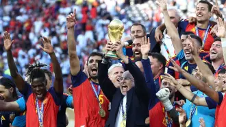 El seleccionador español Luis De La Fuente levanta el trofeo de la Copa Mundial junto a sus compañeros mientras celebran la victoria.