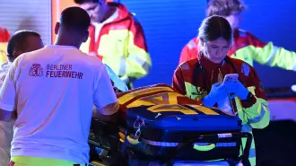Personal de emergencia y agentes de policía trabajan cerca del lugar donde una persona murió y unas 15 resultaron heridas después de que, al parecer, un automóvil atropellara a la multitud.