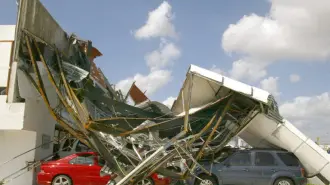 Estado que presenta el 24 de octubre de 2005 una agencia de automotores destruida por el Huracán Wilma, en el centro de Cancún, México. En la central de autobuses de Cancún, cientos de personas, mexicanos y extranjeros, se confunden en una interminable fila. Todos esperan conseguir un boleto para abordar uno de la docena autobuses que este lunes salen a Mérida, capital del vecino Yucatán localizada a 320 km. AFP PHOTO/ Alfredo ESTRELLA (Photo by ALFREDO ESTRELLA / AFP)