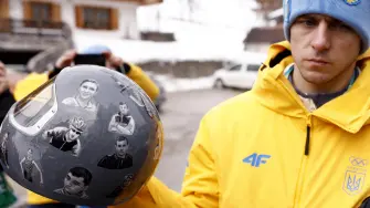 Ukraine's skeleton racer Vladyslav Heraskevych holds his helmet, which depicts victims of his country's war with Russia, in Cortina d'Ampezzo on February 12, 2026. Heraskevych was disqualified from the Winter Olympics on February 12, 2026 after refusing to back down over his banned helmet, which depicts victims of his country's war with Russia.The International Olympic Committee said he had been kicked out of the Milan-Cortina Games "after refusing to adhere to the IOC athlete expression guidelines". (Photo by Odd ANDERSEN / AFP)