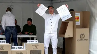 El presidente colombiano Gustavo Petro muestra las papeletas de votación antes de emitir su voto.
