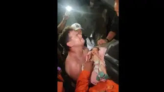 Captura de pantalla tomada de un video publicado en IG que muestra a un bebé recién nacido siendo rescatado con vida de entre los escombros en la ciudad de La Guaira, Venezuela.