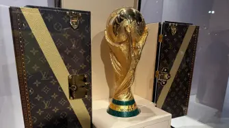 Réplica del trofeo de la Copa Mundial exhibida en un baúl para trofeos de Louis Vuitton.