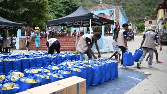 Trabajadores distribuyen donaciones del Programa Mundial de Alimentos (PMA) en Chichiriviche de la Costa.
