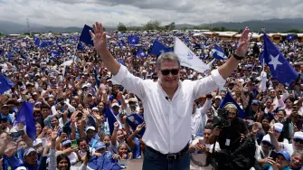 El expresidente hondureño Juan Orlando Hernández hace gestos mientras se reúne con simpatizantes tras su llegada.