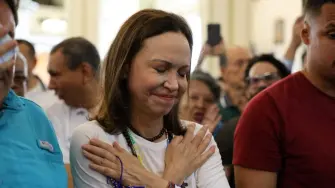 La líder de la oposición venezolana, María Corina Machado, hace un gesto al llegar a una iglesia tras regresar al país después de casi un año en el extranjero.