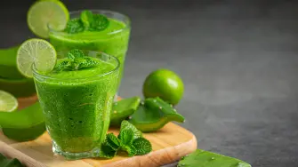 two glasses of aloe vera  juice put on wooden cutting board