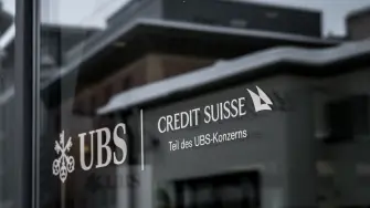 This photograph shows a sign of the Credit Suisse which reads in German as 'part of the UBS group' and displayed on a branch of Swiss banking giant UBS in the resort of St. Moritz on December 20, 2024. - Switzerland's financial regulator was ineffective in tackling the scandals at Credit Suisse, where executive mismanagement scuppered the bank and nearly triggered a global financial crisis, a Swiss inquiry concluded on December 20, 2024. (Photo by Fabrice COFFRINI / AFP)