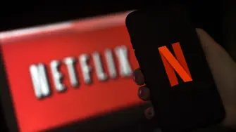 Netflix logo en pantalla y móvil.