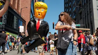 Ciudadana de Chicago golpea una piñata del presidente estadounidense Donald Trump, durante una protesta contra la llegada de agentes del ICE y la Guardia Nacional.