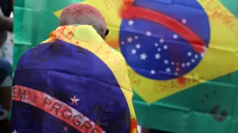 Una persona envuelta en una bandera brasileña marcada con manchas de sangre falsa protesta, al día siguiente de una operación policial mortal contra el narcotráfico en la favela do Penha, en Río de Janeiro, Brasil, 29 de octubre de 2025.